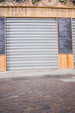 Caddedeki ahşap yüzlü bir bar dükkanının kapalı perdeleri.