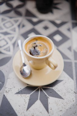 Krem bej bir fincanda güçlü siyah Espresso Masada oturuyor