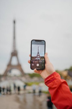 Smartphone 'la el ele tutuşup Paris' te seyahat ederken Eyfel Kulesi 'nin fotoğrafını çekiyoruz.