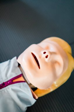 Sağlık ve eğitim ortamlarında acil tıp eğitimi ve ilk yardım uygulamaları için kullanılan bir paspasın üzerinde yatan bir suni teneffüs eğitimine yakından bakın..