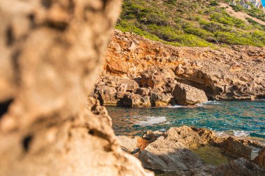 Engebeli kıyı şeridini vurucu uçurumlarıyla, berrak gök mavisi sularıyla ve canlı yeşillikleriyle keşfedin. Bu sakin kıyı manzarası, güneşli bir günde el değmemiş doğal güzelliğin özünü yakalar.
