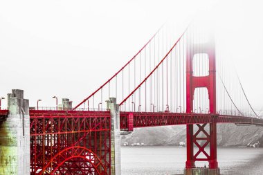 A stunning view of the Golden Gate Bridge enveloped in fog, capturing the iconic structure's majestic red architecture against a muted sky, creating a mystical feel over San Francisco Bay. clipart