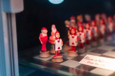 Close-up of whimsical card soldier figurines in red and white, showcasing creativity and fantasy from the Alice in Wonderland theme, displayed on a chessboard. clipart