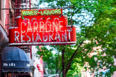 Kırmızı ve yeşil renkte parlayan canlı, neon renkli bir restoran tabelası, tarihi bir şehir ortamında zarif bir şekilde asılı duruyor, nostalji ve klasik cazibeyi çağrıştırıyor..
