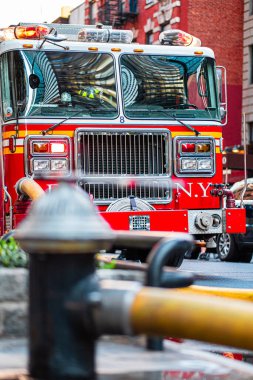 A vibrant red fire truck in a bustling urban area, equipped with hoses and sirens, reflects the dynamic city environment. The image emphasizes emergency readiness and the vital role of firefighters. clipart