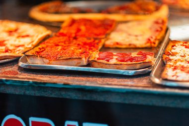 Biberli ve domates soslu bir dizi pizza, sıcak ve davetkar bir fırın ortamının özünü yakalamak için bir tepside güzelce sergileniyor..