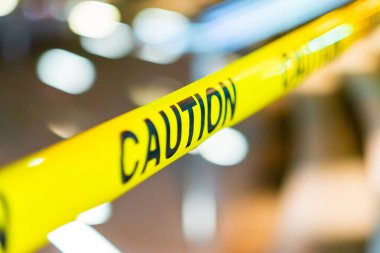 Kısıtlı ya da kontrollü bir bölgede güvenlik önlemleri, tehlike farkındalığı ve güvenlik protokollerini temsil eden bulanık bir geçmişe karşı koyu metin içeren sarı uyarı bandı..