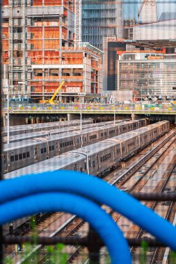 Çağdaş bina inşaatı devam eden kentsel gelişim ve taşımacılığı vurgulayan hareketli bir şehir manzarasının dinamik altyapısını sergiliyor..