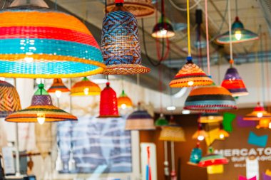 Woven lampshades hanging in a modern indoor marketplace, combining traditional craftsmanship with contemporary design clipart