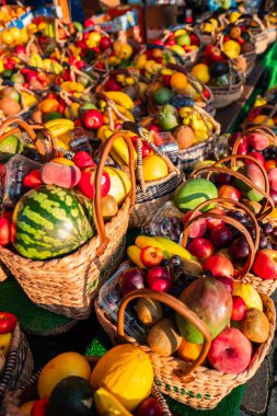 Dokuma sepetlerinin canlı meyve ve sebzelerle dolu olduğu açık hava pazarı, doğal üretimin zenginliğini ve çeşitliliğini gösteriyor, sağlıklı ve organik bir yaşam tarzı için mükemmel.