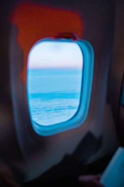 A breathtaking view of clouds and the horizon seen through an airplane window, capturing the essence of travel and adventure high above the earth. clipart