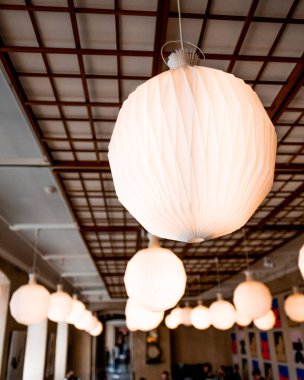 Güzel kağıt fenerler, modern dekorun gelişmesi ve davetkar bir atmosfer yaratması için zarif bir kafeyi ılık ışıkla hafifçe aydınlatır. Tasarım uzaya biraz sofistike bir dokunuş katıyor.