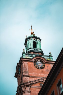 Avrupa şehir merkezindeki saat kulesi mimarisi gökyüzüne karşı kurulmuş. Yapının tarihi cazibesi ve kentsel güzelliği sonsuz zarafet ve kültürel öneme sahip bir atmosfer yaratıyor.