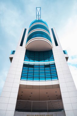 Bina, bulutlu bir gökyüzüne karşı çarpıcı bir etki yaratan parlak cam cepheler ve geometrik tasarımlar içeriyor. Modern mimari ve kentsel gelişimin mükemmel bir temsili.