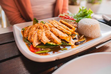 Canlı sebzelerle çevrili susam tohumlu, iştah açıcı Tayland tavuğu ve pilav. Harika bir aşçılık deneyimi ve zengin Asya tatları için mükemmel..