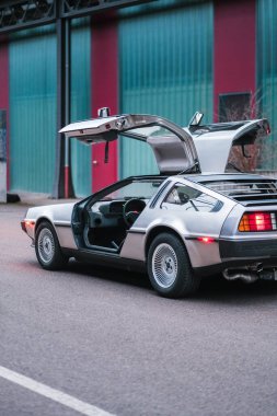 Martı kanat kapıları açık, şehir sokağına park edilmiş klasik bir DeLorean arabası. Bu klasik 1980 'lerin aracı, retro ve gelecekçi otomotiv hayranlarına hitap eden ikonik bir tasarım..
