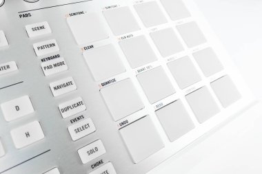 Aydınlatılmış pedler ve kontrol düğmelerinin yer aldığı, elektronik ses oluşturma, ritim oluşturma ve profesyonel müzik üretimi için uygun bir müzik prodüksiyon aracının yüksek çözünürlüklü görüntüsü.