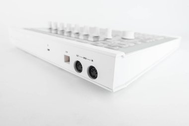 MIDI denetleyici USB ve MIDI girdi ve çıktı bağlantıları, temiz beyaz bir yüzey üzerinde stüdyolar ve ses meraklıları için müzik üretimi ve bağlantı çözümleri sağlar