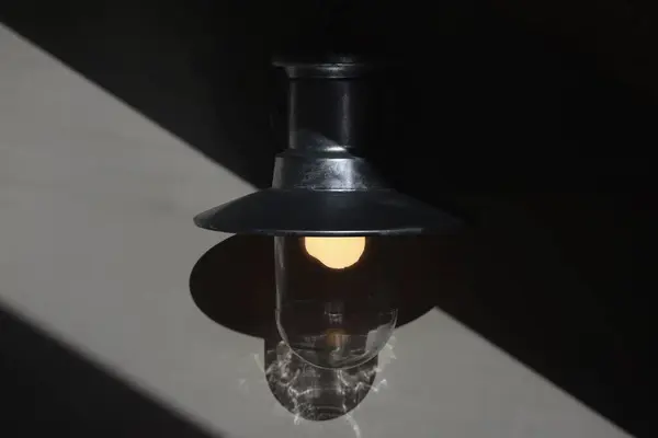 Koyu bir uzayda eski bir lambanın yakın plan çekimi. Metal bir fenerin yumuşak, ılık bir parıltısının yüksek kaliteli fotoğrafı..