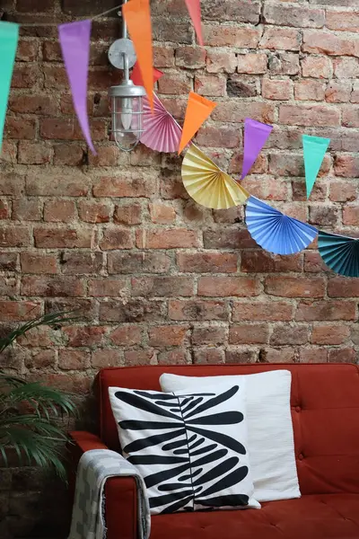 Açığa çıkmış tuğla bir duvarda asılı çelenk süslemeleri olan rahat bir iç mekan. Şenlikli ev dekorasyonu, stok fotoğrafı..