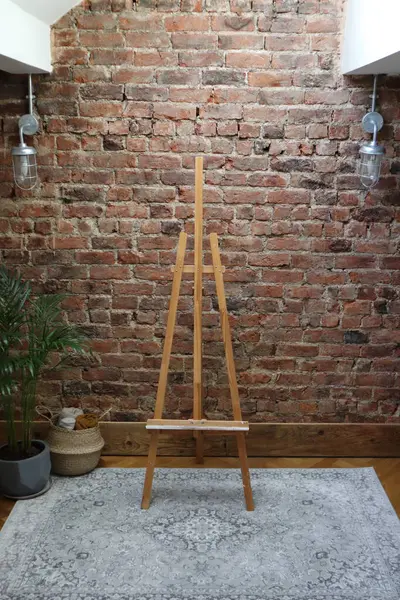 Bu iç düzenek, dokulu kırmızı tuğla bir duvara karşı ahşap bir sehpa içeriyor. İç tasarım ilhamı, sanat temalı projeler veya arkaplan olarak ideal.