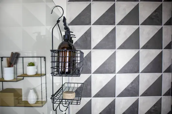 Metal bir duvarın yanında sabun ve şişelerle süslü bir duş taşıyıcısı..