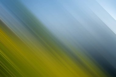 Bu soyut arka plan, modern tasarım ve projeler için ideal, köşegen hareket bulanıklığı etkisi ile dinamik bir kompozisyon oluşturan mavi, yeşil ve sarı tonların bir karışımını içerir..