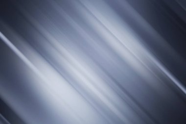 Mavi ve gümüş ışığın köşegen çizgilerini içeren dinamik soyut bir arka plan, pürüzsüz, bulanık efektli bir hız ve gelecek teknolojisi yaratıyor..