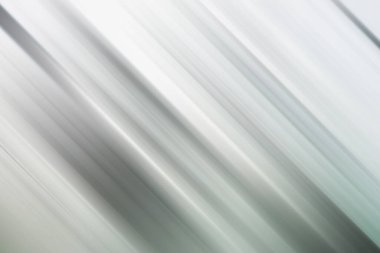 Gri ve beyaz tonlarında gösterilen ve hız ve modernlik hissi uyandıran çapraz çizgiler içeren soyut bir arkaplan..