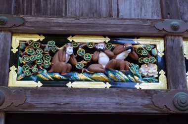 Japonya 'nın Nikko kentindeki bir türbeye tahta oyulmuş üç ünlü maymunun yakın plan fotoğrafı.