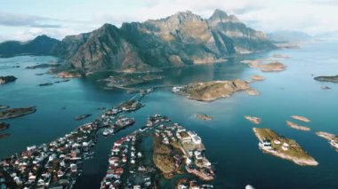 Etrafı dağlarla çevrili Norveç balıkçı kasabasının hava aracı manzarası ve güzel deniz, Lofoten adaları, Henningsvar