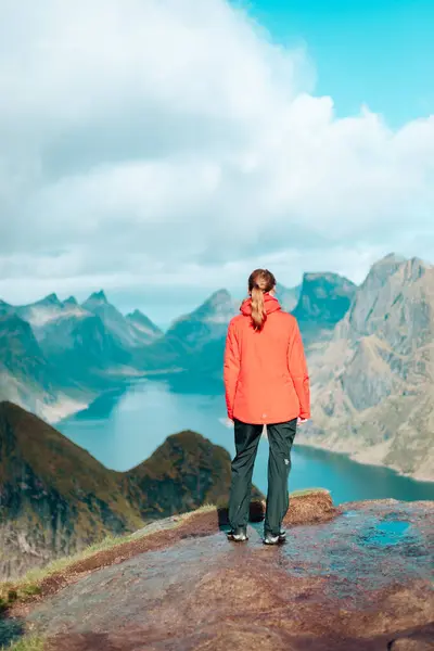 Fiyort manzarası. Kız turist Reinebringen Dağı 'nın yamacında duruyor. Güzel dağ manzarası. Doğa Norveç, Lofoten Adaları, Reine