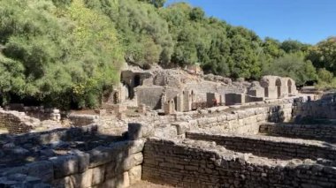 Butrint Ulusal Arkeoloji Parkı. Sarand yakınlarındaki Albana 'nın güneyindeki antik Roma şehri harabeleri. Mavi gökyüzüyle güneşli bir yaz günü. Eski Roma harabeleri, taşlar ve binalar.