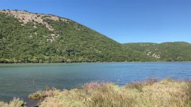 Arnavutluk 'ta Butrint Ulusal Arkeoloji Parkı yakınlarındaki Southern Hills ve Butrint Gölü. Güneşli, güneşli bir gün. Arka planda yuvarlanan tepeler manzaralı.