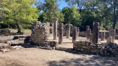 Butrint Ulusal Arkeoloji Parkı. Sarand yakınlarındaki Albana 'nın güneyindeki antik Roma şehri harabeleri. Mavi gökyüzüyle güneşli bir yaz günü. Eski Roma harabeleri, taşlar ve binalar.