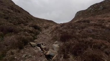 İskoçya İskoçya 'da tepe yürüyüşü. Aberfeldy, Perthshire yakınlarındaki Dun Coillich tepesinde. Schihallian adı verilen ünlü Munro dağının yakınında sık sık uzaklarda belirir. Sonbahar renkleri ve kahverengi fundalık arazide büyüyor..
