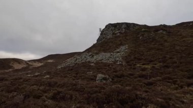 İskoçya İskoçya 'da tepe yürüyüşü. Aberfeldy, Perthshire yakınlarındaki Dun Coillich tepesinde. Schihallian adı verilen ünlü Munro dağının yakınında sık sık uzaklarda belirir. Sonbahar renkleri ve kahverengi fundalık arazide büyüyor..