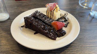 Çikolatalı keki güzel bir şekilde dondurma ve çilekle sundun. Güzel yemek. Şefin spesiyali. Tatlı.