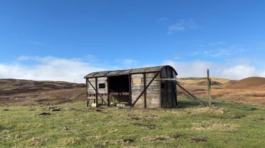 İskoç dağlarında kışın karla kaplı terk edilmiş eski, yıkık dökük tren vagonu. İskoçya 'da açık havada yuvarlanan tepeler. Güzel kırsal kesimde vahşi doğa manzarası