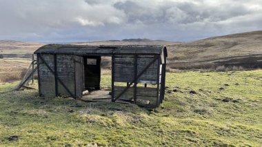 İskoç dağlarında kışın karla kaplı terk edilmiş eski, yıkık dökük tren vagonu. İskoçya 'da açık havada yuvarlanan tepeler. Güzel kırsal kesimde vahşi doğa manzarası