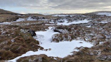 İskoç dağları kışın karla kaplı. İskoçya 'da açık havada yuvarlanan tepeler. Güzel kırsal kesimde vahşi doğa manzarası