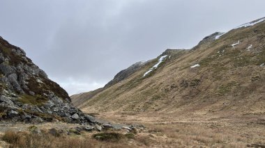 İskoç dağları kışın karla kaplı. İskoçya 'da açık havada yuvarlanan tepeler. Güzel kırsal kesimde vahşi doğa manzarası