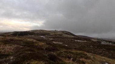 İskoçya 'nın Crieff yakınlarındaki Scurran dağında yürüyüş. Doğada tepe yürüyüşü, ilkbaharda açık hava, kar ve fundalık. Yuvarlanan dağlar