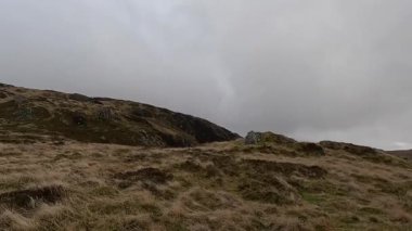 İskoçya 'nın Crieff yakınlarındaki Scurran dağında yürüyüş. Doğada tepe yürüyüşü, ilkbaharda açık hava, kar ve fundalık. Yuvarlanan dağlar