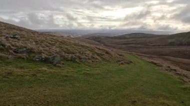 İskoçya 'nın Crieff yakınlarındaki Meall Tarsuinn dağında yürüyüş. Doğada tepe yürüyüşü, ilkbaharda açık hava, kar ve fundalık. Yuvarlanan dağlar