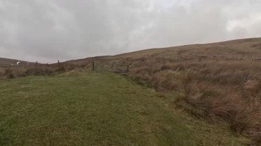 İskoçya 'nın Crieff yakınlarındaki Meall Tarsuinn dağında yürüyüş. Doğada tepe yürüyüşü, ilkbaharda açık hava, kar ve fundalık. Yuvarlanan dağlar