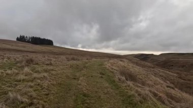 İskoçya 'nın Crieff yakınlarındaki Meall Tarsuinn dağında yürüyüş. Doğada tepe yürüyüşü, ilkbaharda açık hava, kar ve fundalık. Yuvarlanan dağlar