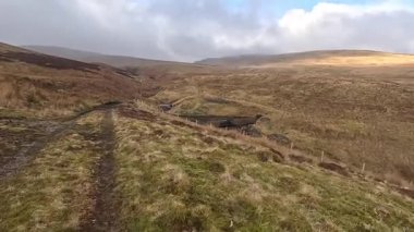 İskoçya 'nın Crieff yakınlarındaki Meall Tarsuinn dağında yürüyüş. Doğada tepe yürüyüşü, ilkbaharda açık hava, kar ve fundalık. Yuvarlanan dağlar