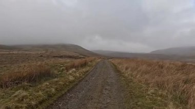 İskoçya 'nın Crieff yakınlarındaki Meall Tarsuinn dağında yürüyüş. Doğada tepe yürüyüşü, ilkbaharda açık hava, kar ve fundalık. Yuvarlanan dağlar