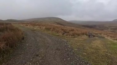 İskoçya 'nın Crieff yakınlarındaki Meall Tarsuinn dağında yürüyüş. Doğada tepe yürüyüşü, ilkbaharda açık hava, kar ve fundalık. Yuvarlanan dağlar